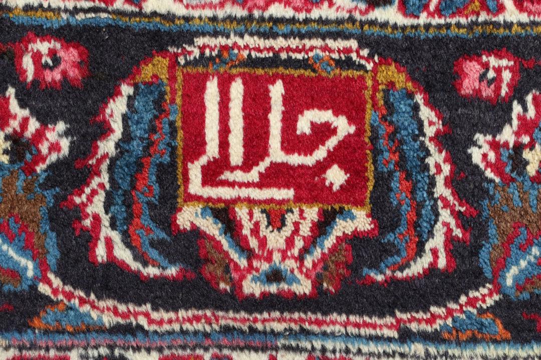 Hand-knotted Mashad rug from the Middle East in red with floral patterns.