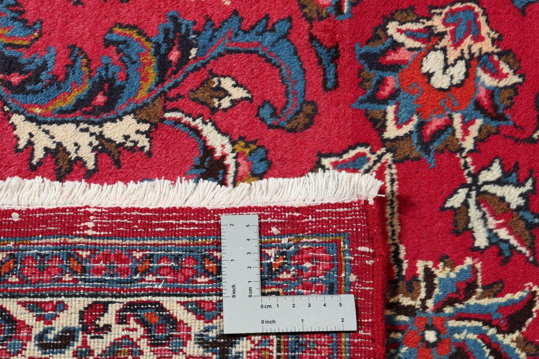 Hand-knotted Mashad rug from the Middle East in red with floral patterns.