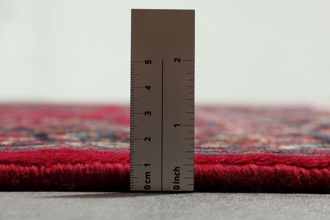 Hand-knotted Mashad rug from the Middle East in red with floral patterns.