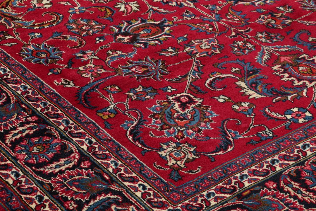 Hand-knotted Mashad rug from the Middle East in red with floral patterns.