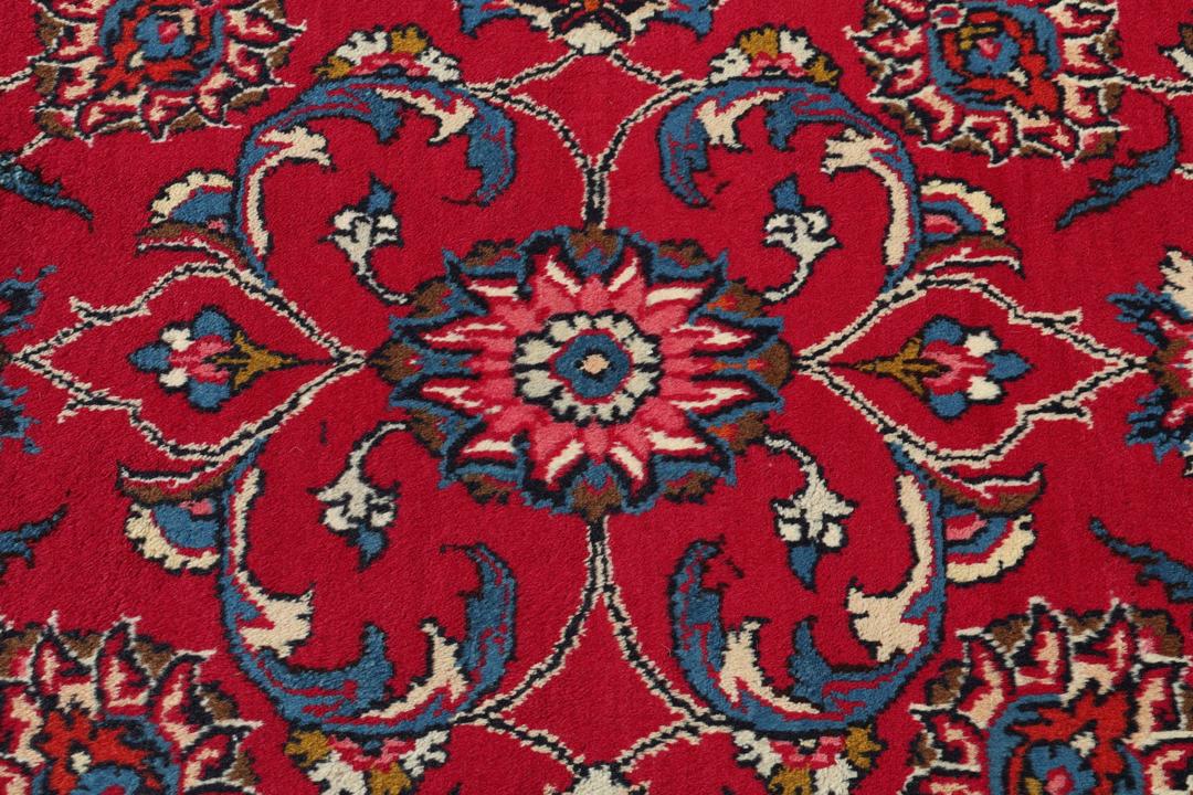 Hand-knotted Mashad rug from the Middle East in red with floral patterns.