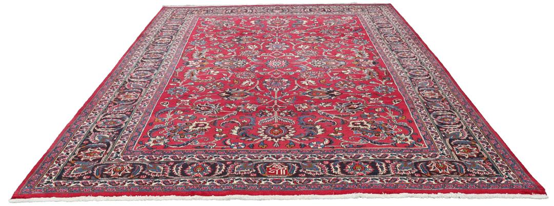 Hand-knotted Mashad rug from the Middle East in red with floral patterns.