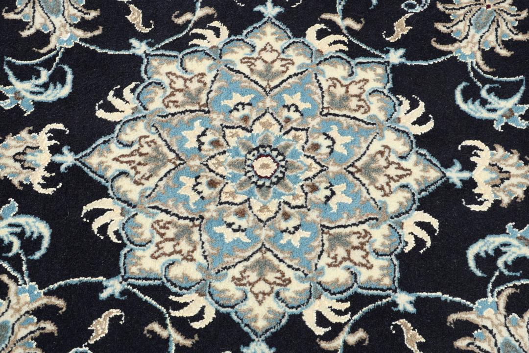 A sophisticated hand-knotted Nain rug from the Middle East with a dark-blue and beige floral pattern.