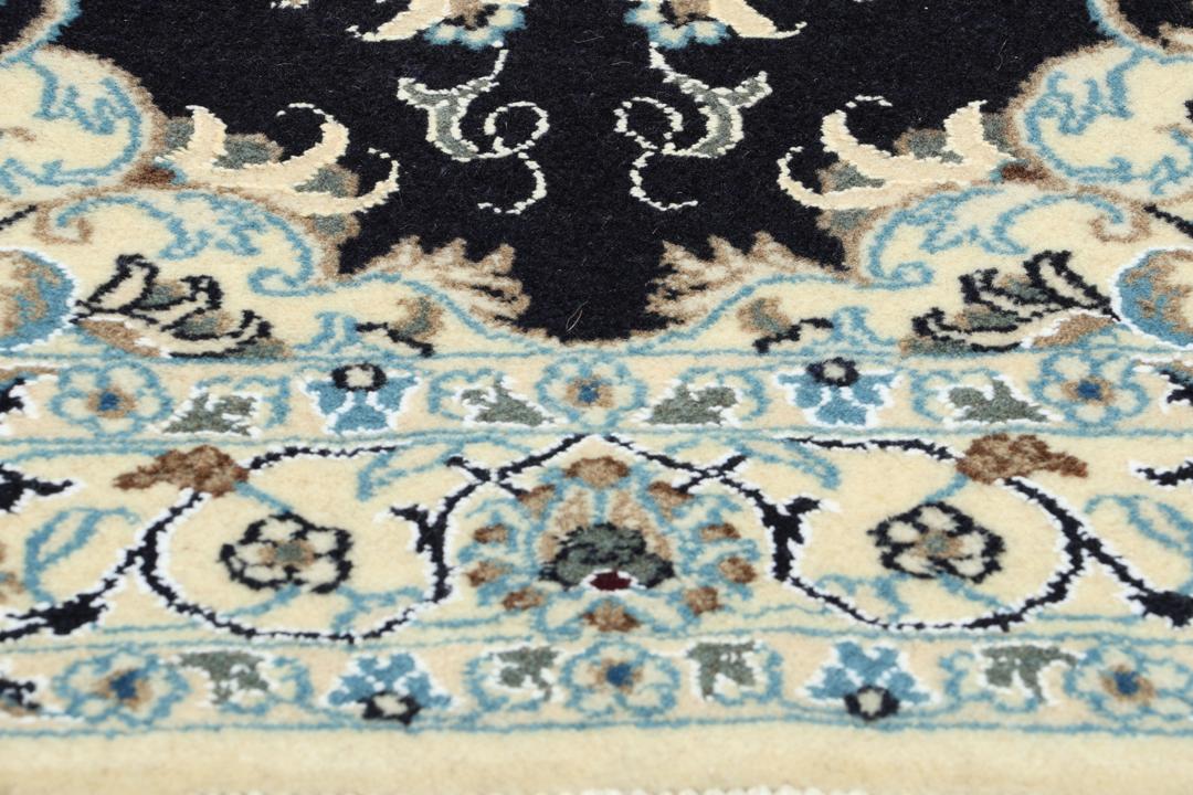 A sophisticated hand-knotted Nain rug from the Middle East with a dark-blue and beige floral pattern.