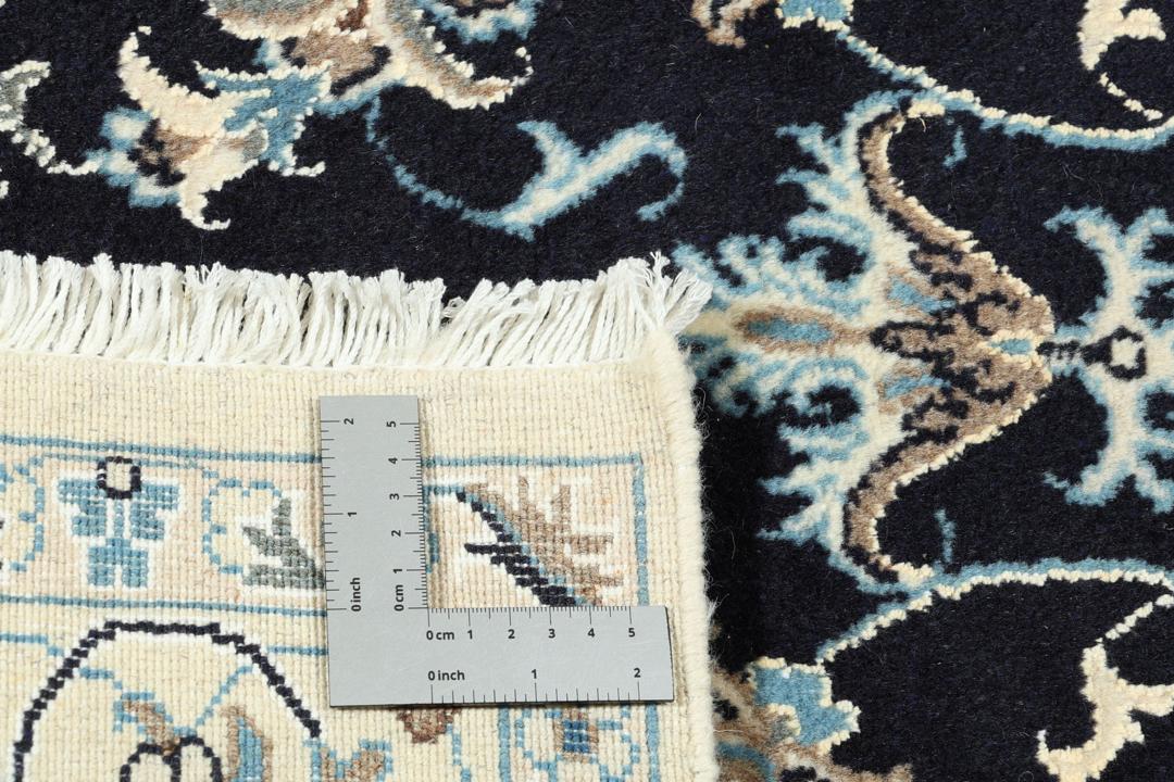 A sophisticated hand-knotted Nain rug from the Middle East with a dark-blue and beige floral pattern.