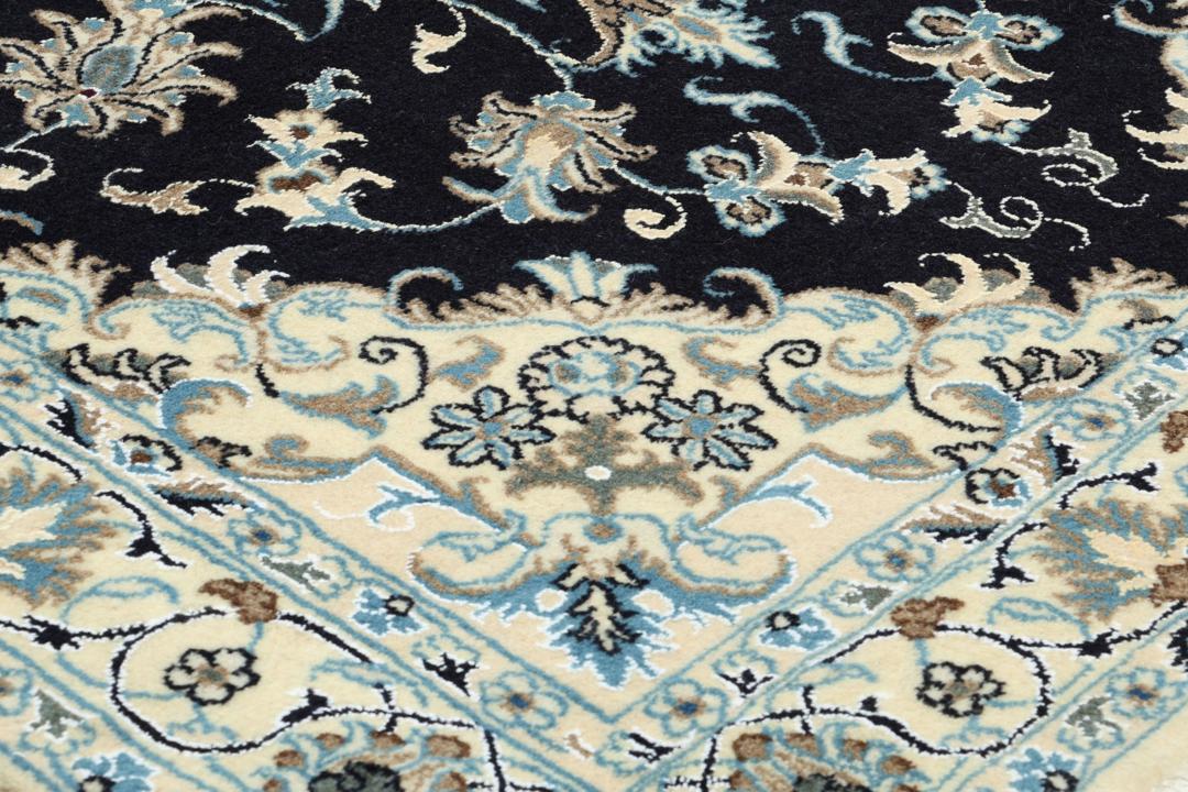 A sophisticated hand-knotted Nain rug from the Middle East with a dark-blue and beige floral pattern.