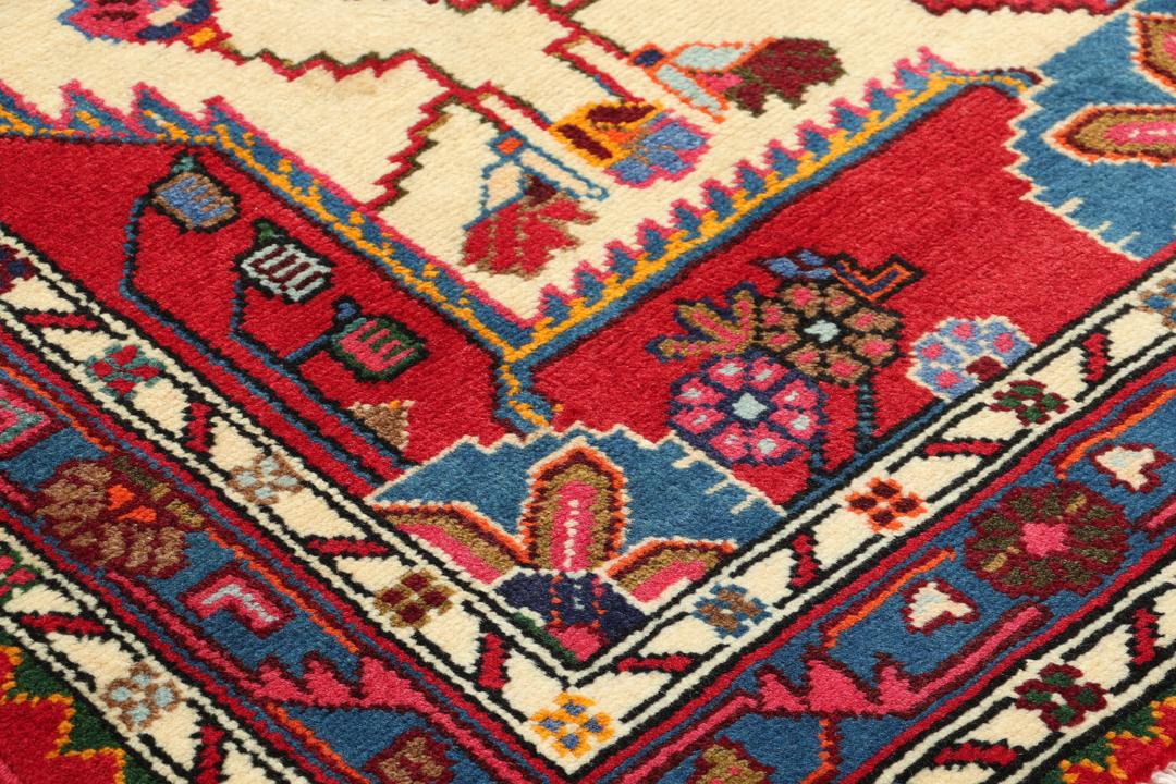 Hand-knotted Hamadan rug featuring a red field with blue and cream geometric motifs