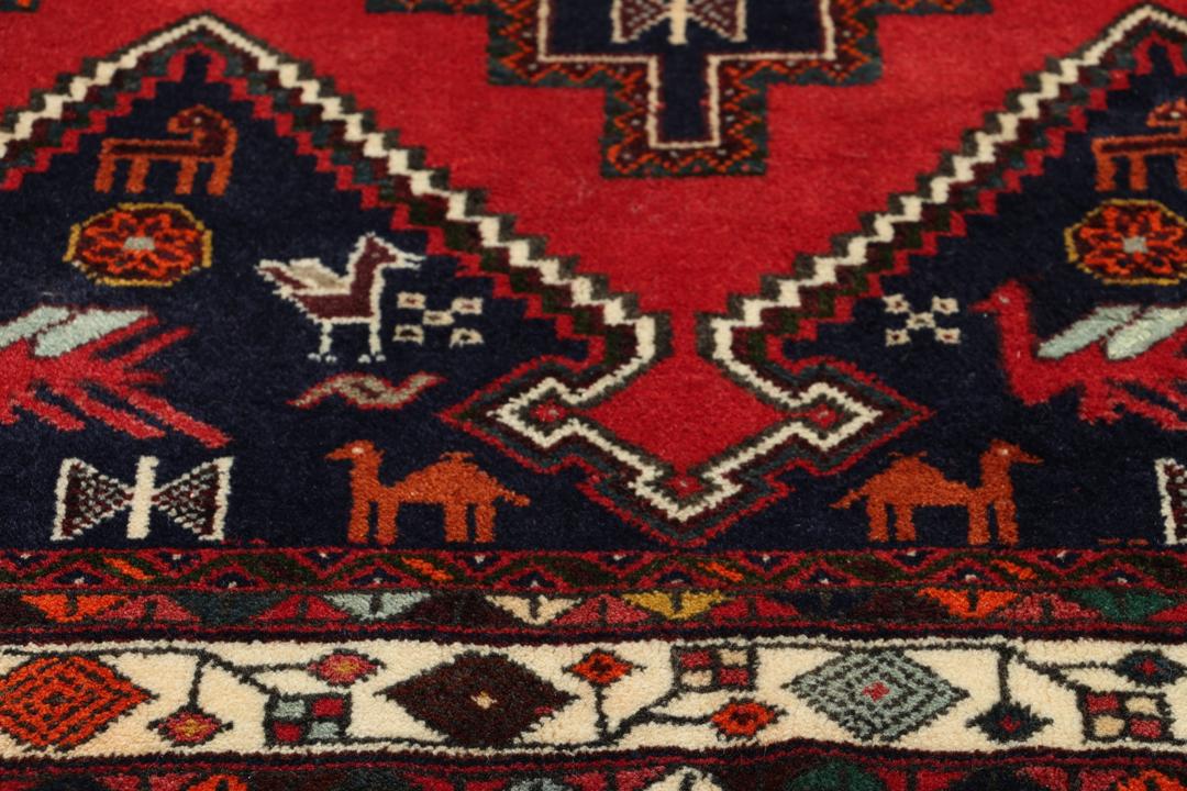 Hand-knotted Afshar rug from the Middle East featuring a red and blue tribal design.