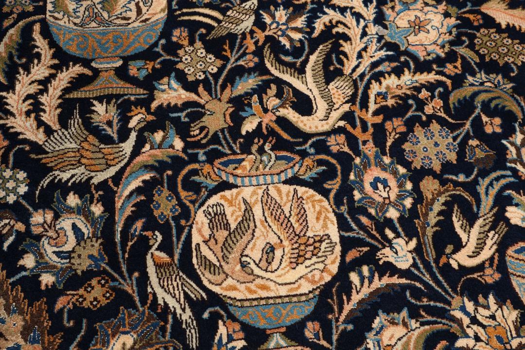 Et rektangulært håndknyttet Kashmar-tæppe fra Mellemøsten med en mørkeblå bund og ornamenterede vasemotiver.