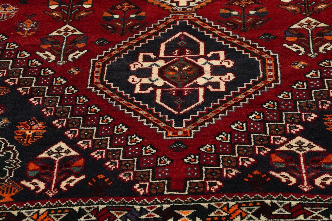 Handmade Shiraz rug from the Middle East featuring a vibrant dark-red and blue geometric design.