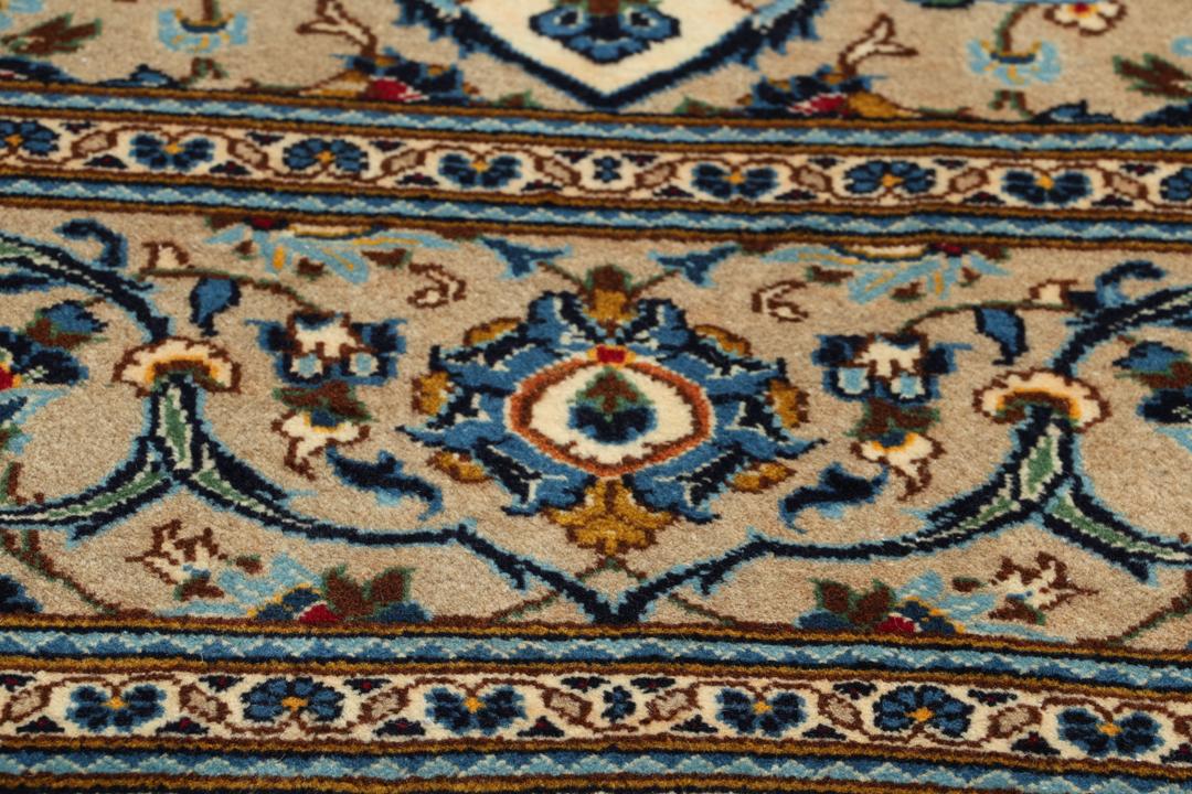 A hand-knotted Keshan rug from the Middle East featuring a blue and beige floral medallion pattern.