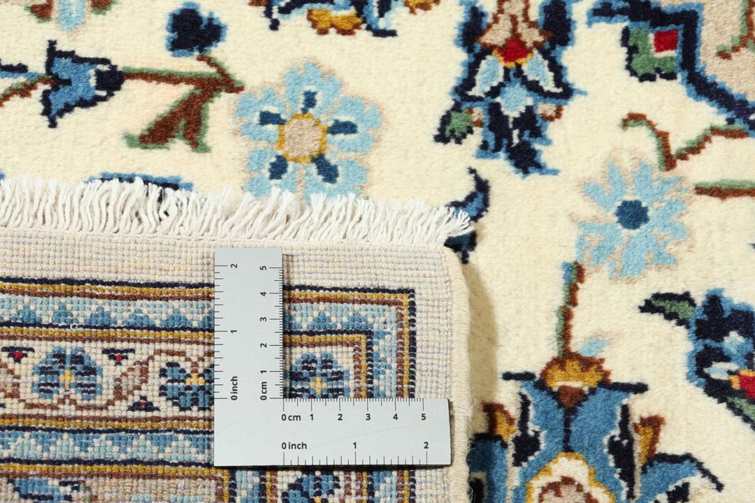A hand-knotted Keshan rug from the Middle East featuring a blue and beige floral medallion pattern.