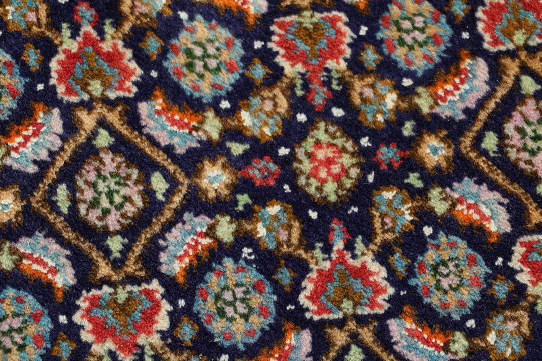 Un tapis rectangulaire Moud du Moyen-Orient présentant un champ bleu profond et des motifs floraux complexes.