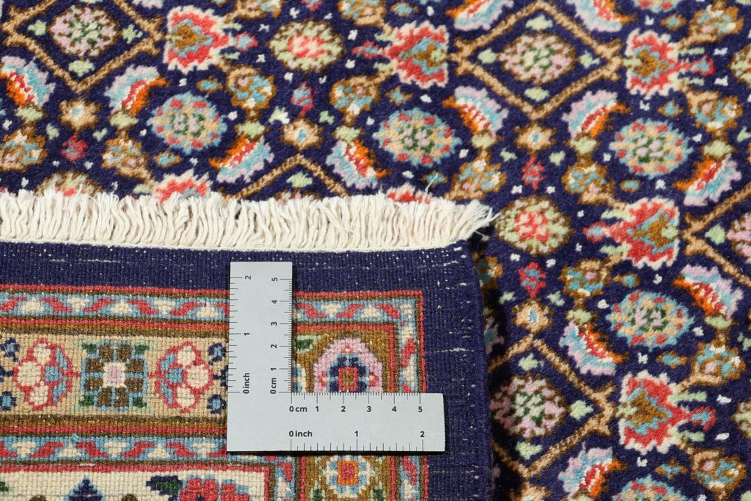 Un tapis rectangulaire Moud du Moyen-Orient présentant un champ bleu profond et des motifs floraux complexes.