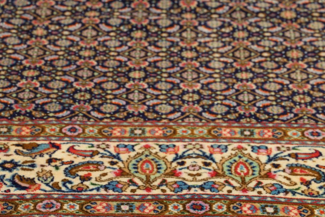 Un tapis rectangulaire Moud du Moyen-Orient présentant un champ bleu profond et des motifs floraux complexes.