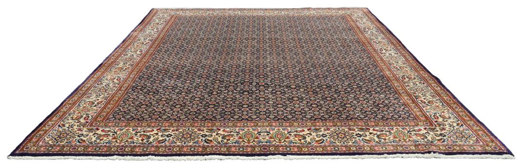 Un tapis rectangulaire Moud du Moyen-Orient présentant un champ bleu profond et des motifs floraux complexes.