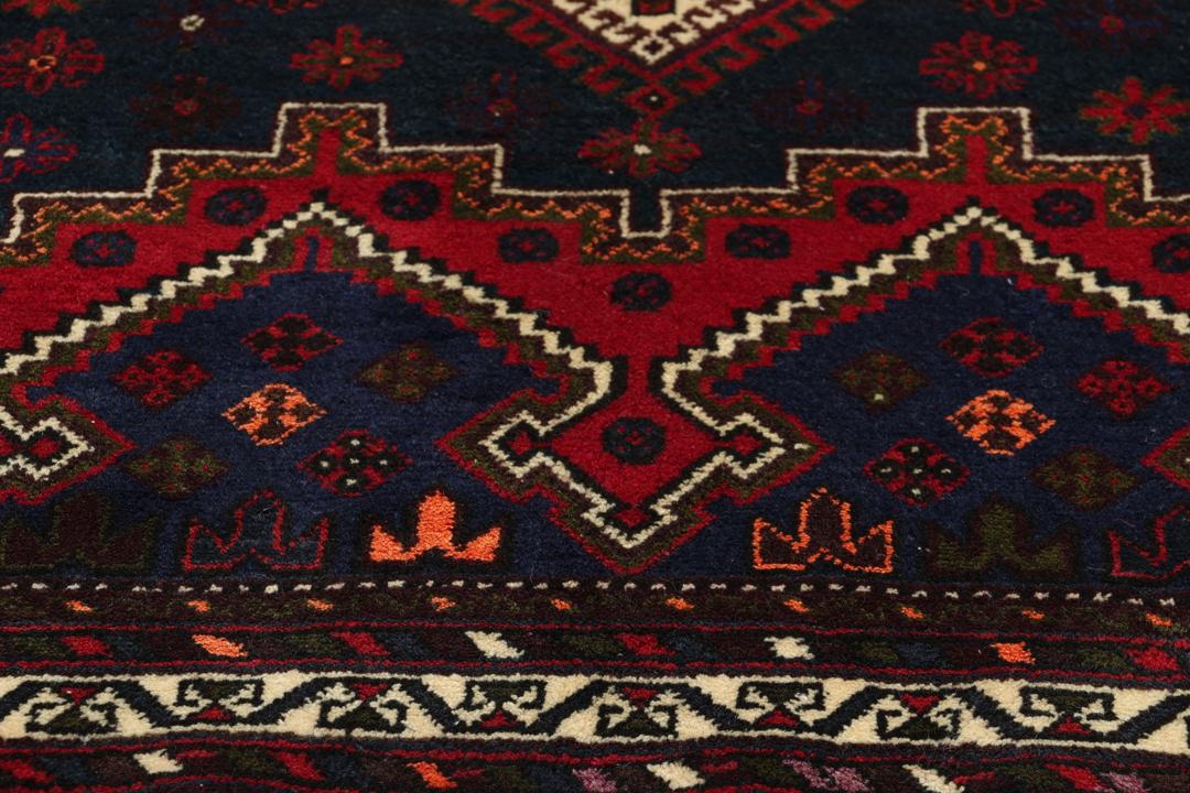 A hand-knotted Afshar rug from the Middle East featuring a vibrant red and blue geometric pattern.
