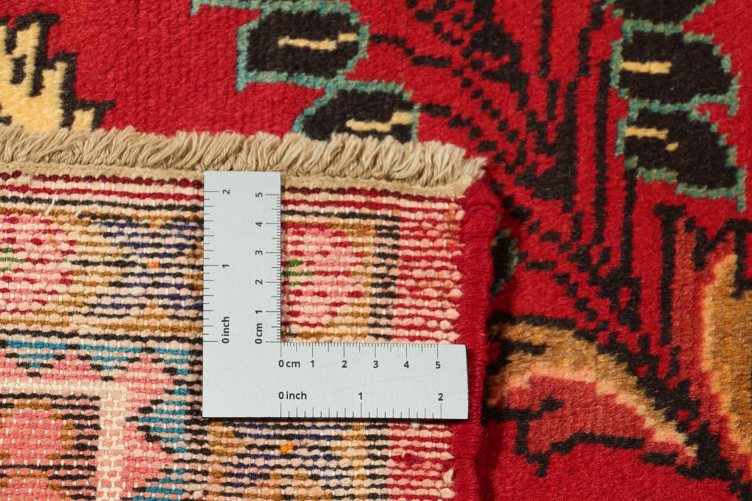 Een handgeknoopt Lillian-tapijt uit het Midden-Oosten met een levendig rood veld en bloemmotieven.