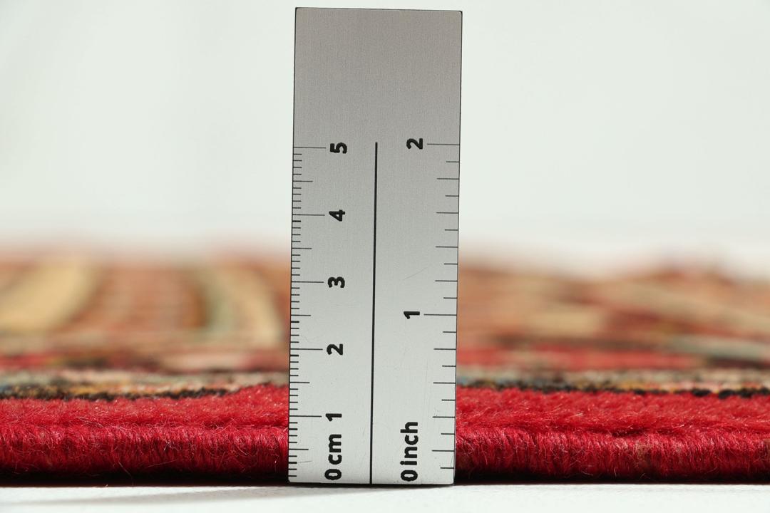 Een handgeknoopt Lillian-tapijt uit het Midden-Oosten met een levendig rood veld en bloemmotieven.