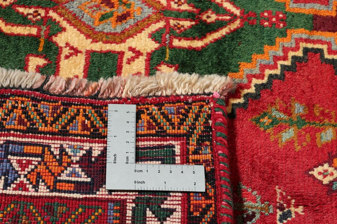 Handgeknoopt tapijt uit het Midden-Oosten met een rood veld en geometrische medaillons