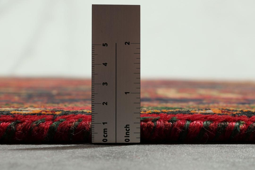 Handgeknoopt tapijt uit het Midden-Oosten met een rood veld en geometrische medaillons