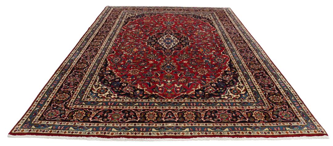 A hand-knotted Mashad rug from the Middle East in deep red and blue tones.
