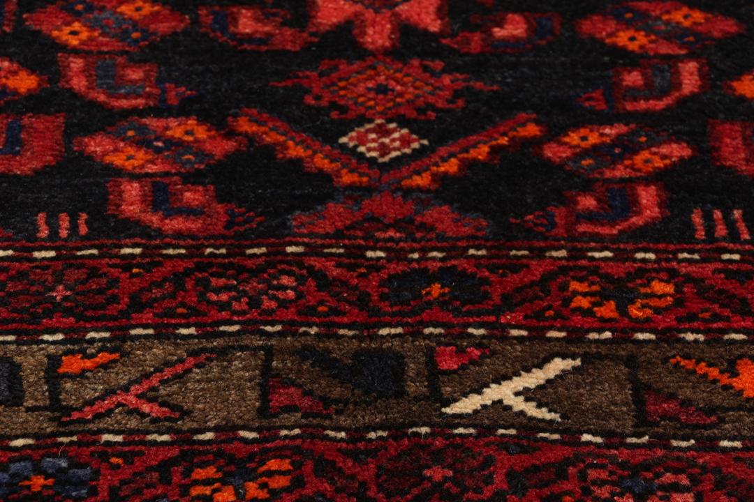 A hand-knotted Hamadan rug from the Middle East in deep red and blue tones.