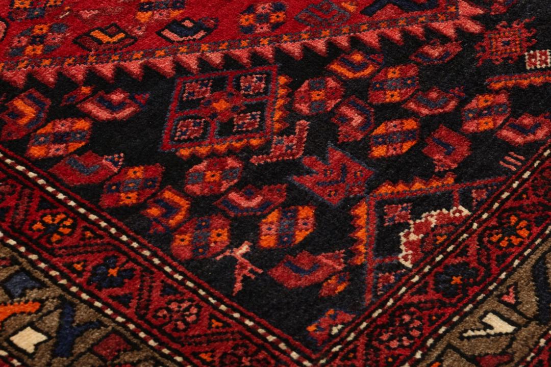 A hand-knotted Hamadan rug from the Middle East in deep red and blue tones.