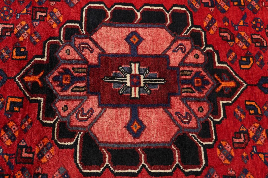 A hand-knotted Hamadan rug from the Middle East in deep red and blue tones.