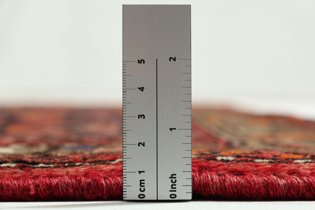 A hand-knotted Hamadan rug from the Middle East in deep red and blue tones.