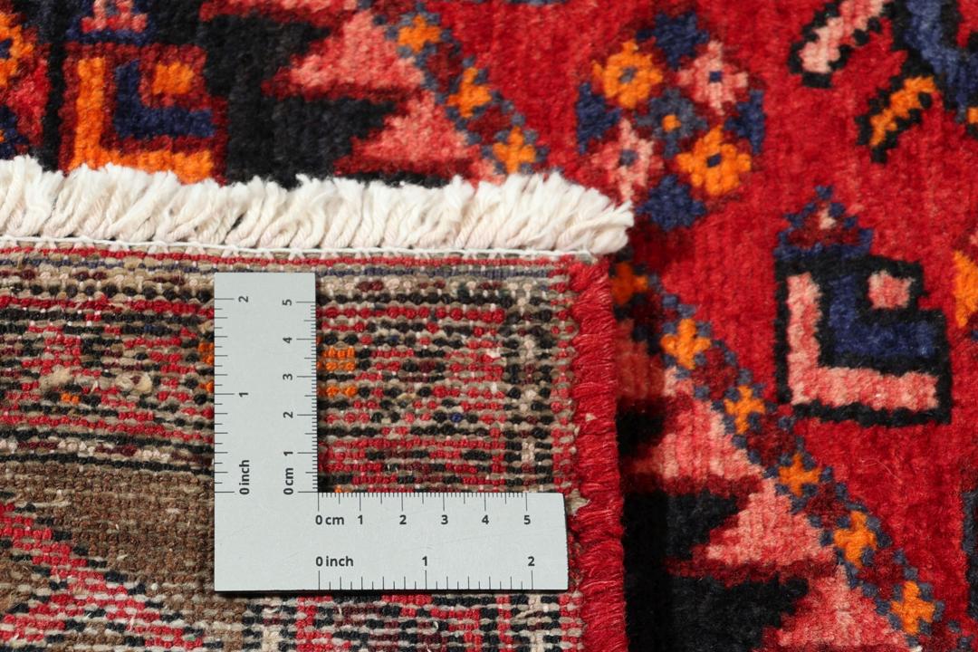 A hand-knotted Hamadan rug from the Middle East in deep red and blue tones.