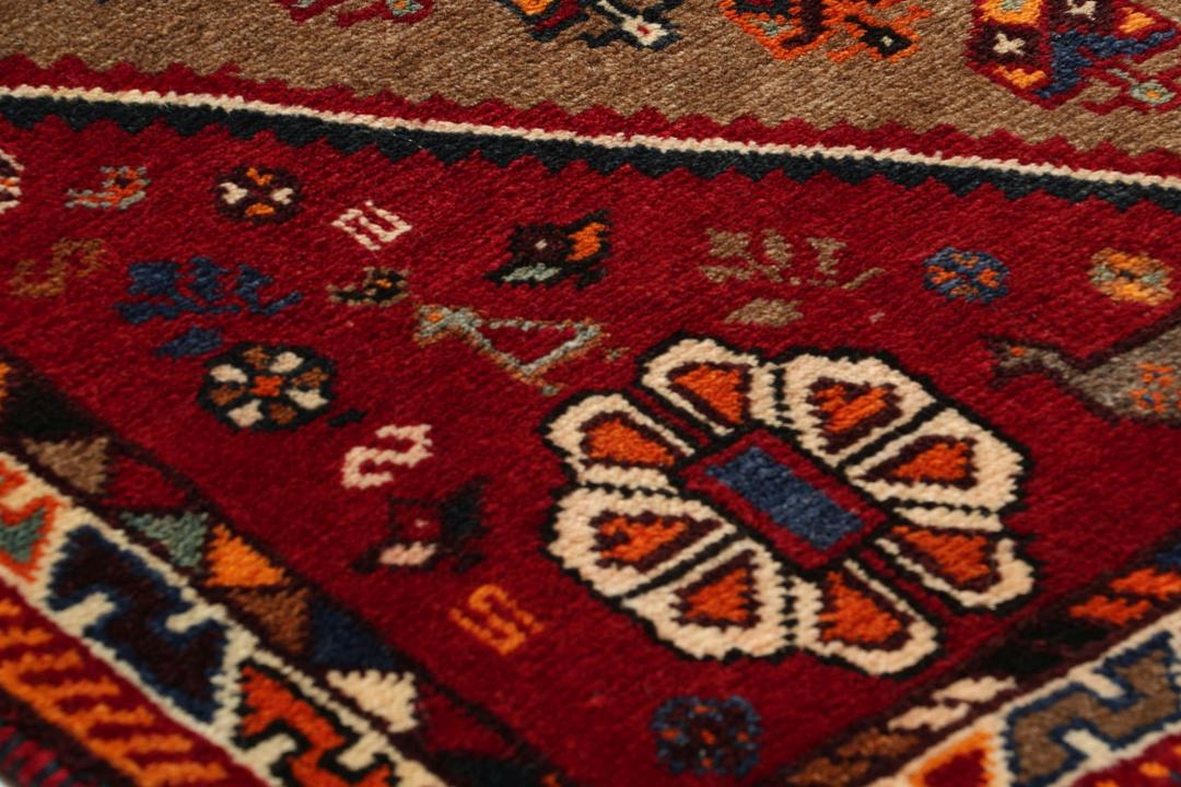 Handgeknoopt Shiraz-tapijt uit het Midden-Oosten met een rood en bruin geometrisch ontwerp.