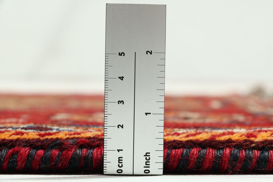 Handgeknoopt Shiraz-tapijt uit het Midden-Oosten met een rood en bruin geometrisch ontwerp.