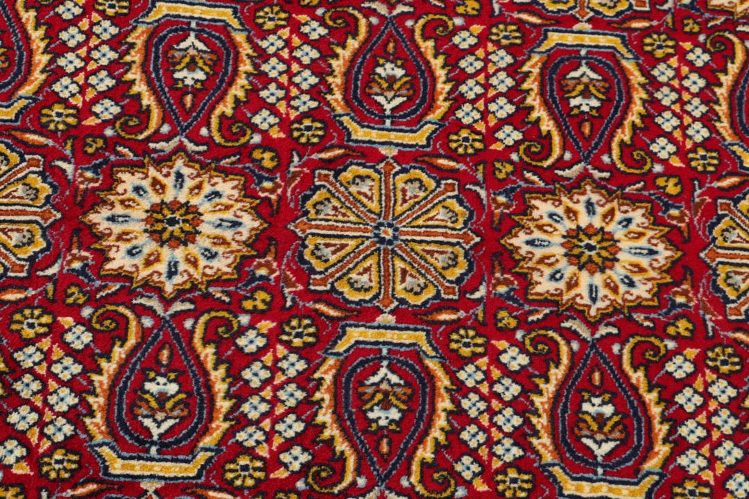 Een handgeknoopt Moud-tapijt uit het Midden-Oosten met een rijk rood veld en decoratieve bloempatronen.