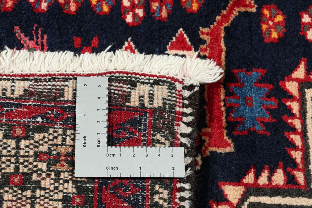 Håndknyttet uldtæppe fra Mellemøsten i mørkeblå og røde nuancer med traditionelle motiver