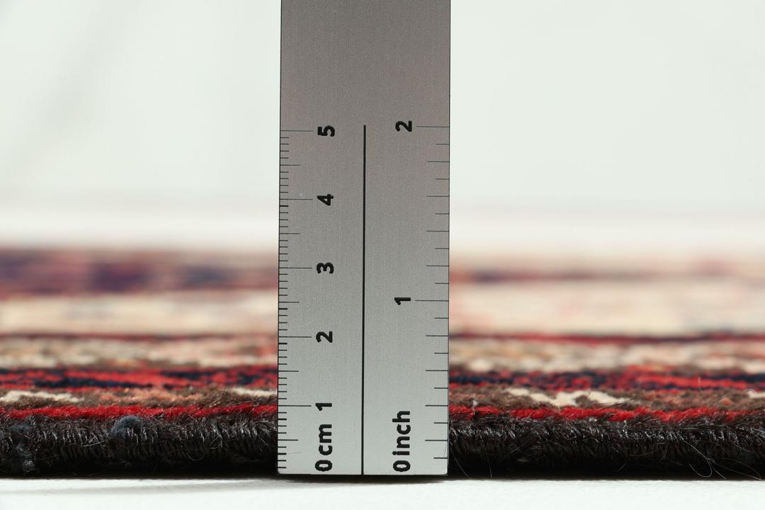 Håndknyttet uldtæppe fra Mellemøsten i mørkeblå og røde nuancer med traditionelle motiver
