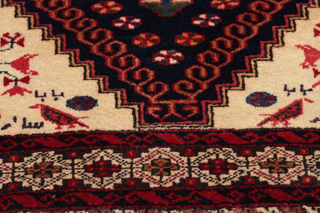Håndknyttet uldtæppe fra Mellemøsten i mørkeblå og røde nuancer med traditionelle motiver
