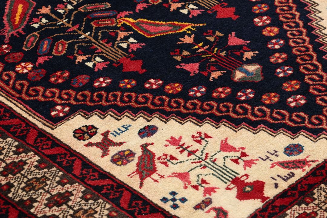Håndknyttet uldtæppe fra Mellemøsten i mørkeblå og røde nuancer med traditionelle motiver