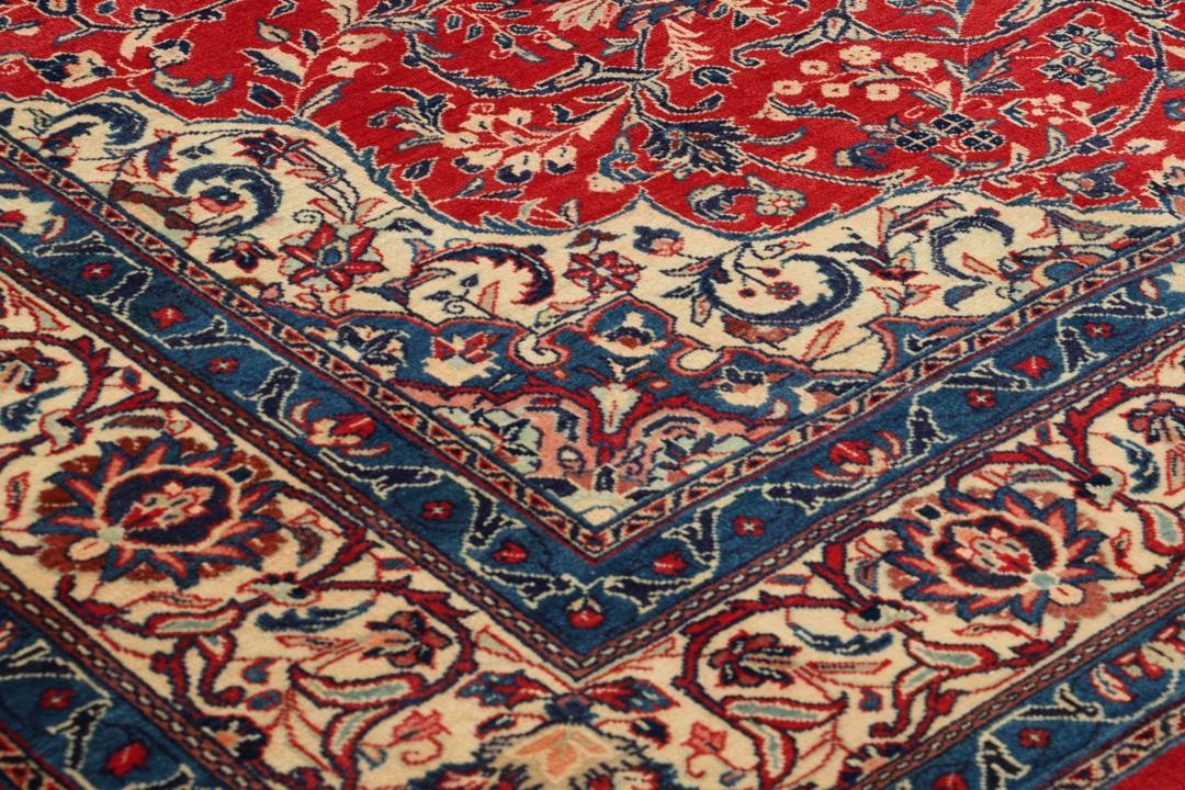 Een handgeknoopt Mahal-vloerkleed uit het Midden-Oosten met een levendig rood en blauw bloemenpatroon.