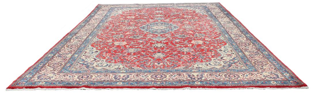 Een handgeknoopt Mahal-vloerkleed uit het Midden-Oosten met een levendig rood en blauw bloemenpatroon.