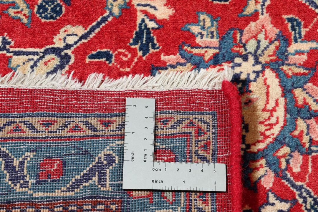 Een handgeknoopt Mahal-vloerkleed uit het Midden-Oosten met een levendig rood en blauw bloemenpatroon.