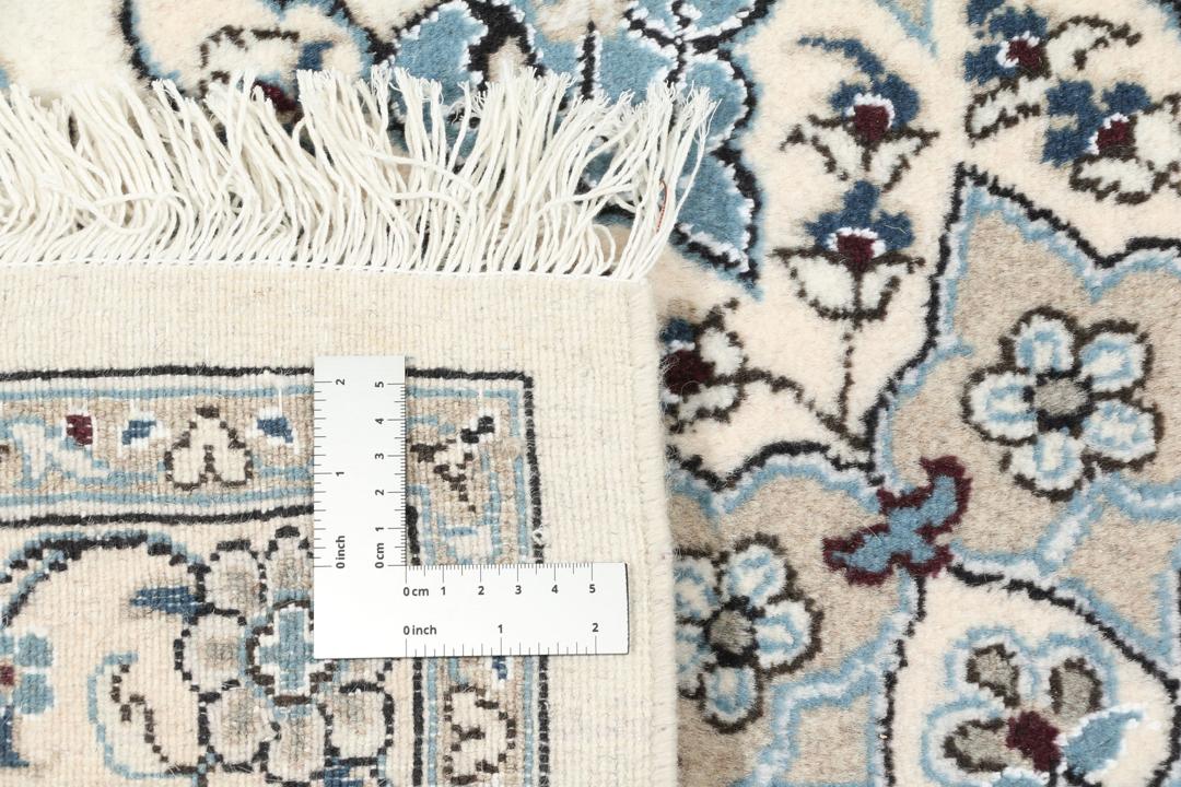 Tapis Nain noué à la main provenant du Moyen-Orient avec un motif floral beige et bleu.
