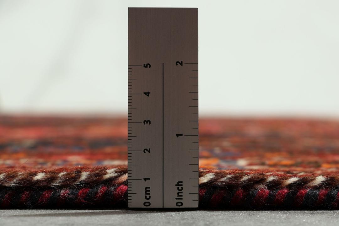Handgeknoopt Shiraz-tapijt uit het Midden-Oosten met een levendig rood en blauw geometrisch ontwerp.