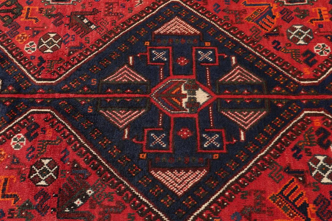 Handgeknoopt Shiraz-tapijt uit het Midden-Oosten met een levendig rood en blauw geometrisch ontwerp.