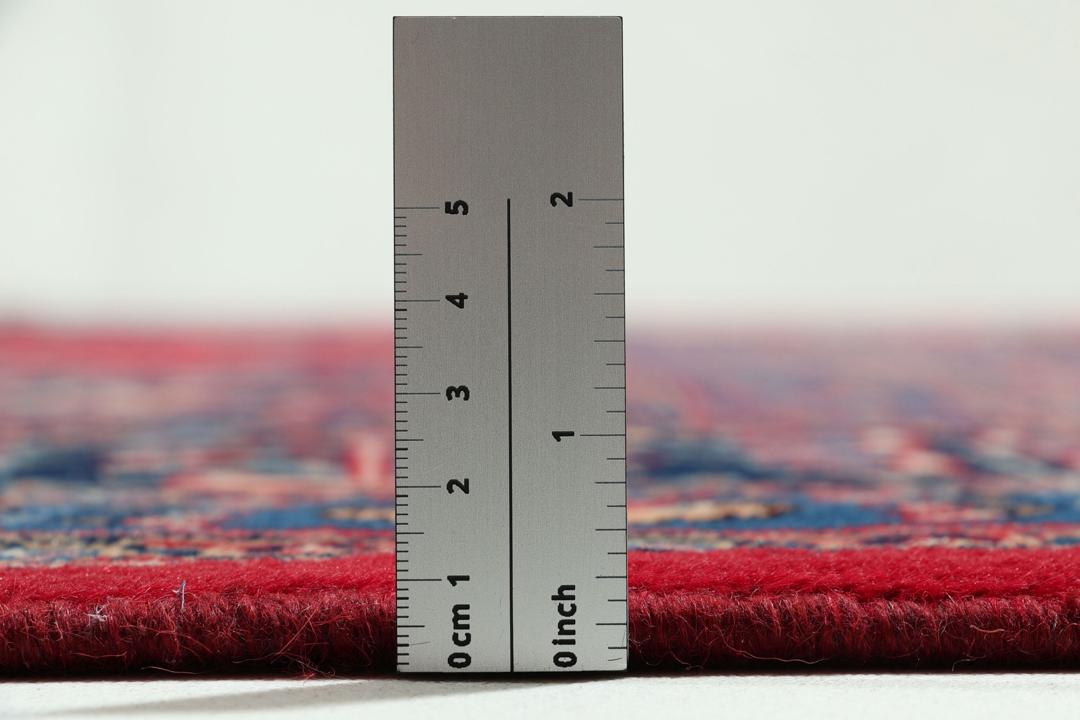 Un tapis Mashad noué à la main avec un médaillon central sur fond rouge provenant du Moyen-Orient