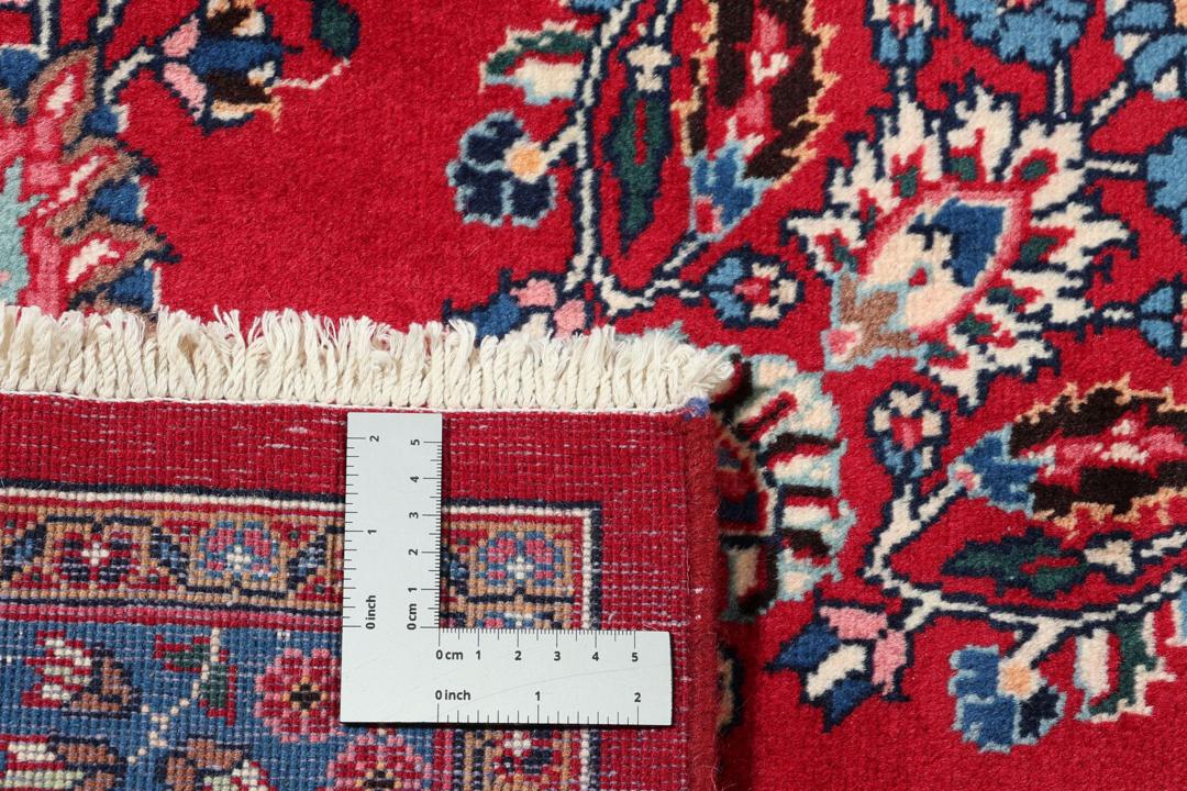 Un tapis Mashad noué à la main avec un médaillon central sur fond rouge provenant du Moyen-Orient