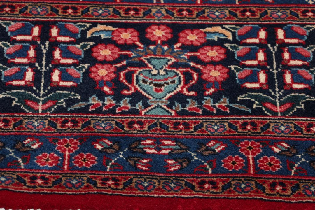 Un tapis Mashad noué à la main avec un médaillon central sur fond rouge provenant du Moyen-Orient
