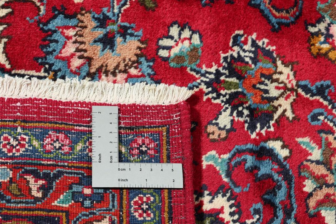 Håndknyttet Mashad-tæppe fra Mellemøsten med en levende rød bund og blomstermønstre.