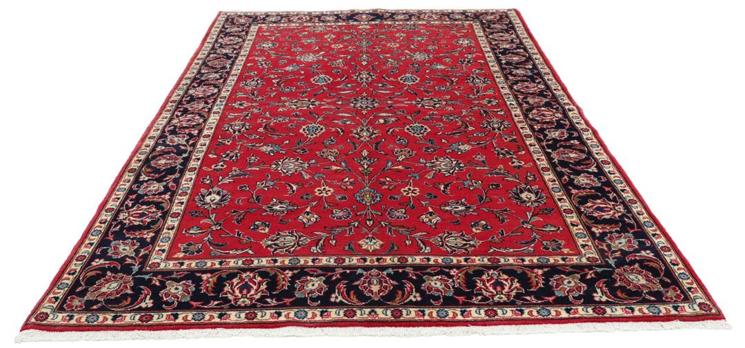 Hand-knotted Keshan rug from the Middle East featuring a vibrant red field with intricate floral patterns.