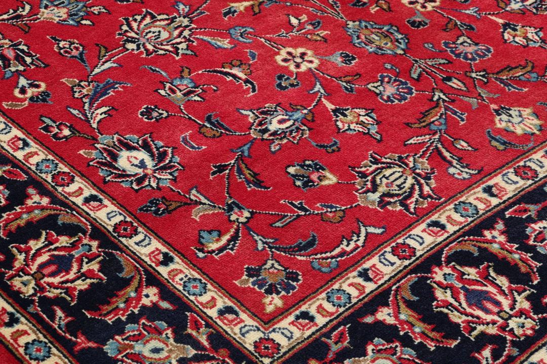 Hand-knotted Keshan rug from the Middle East featuring a vibrant red field with intricate floral patterns.